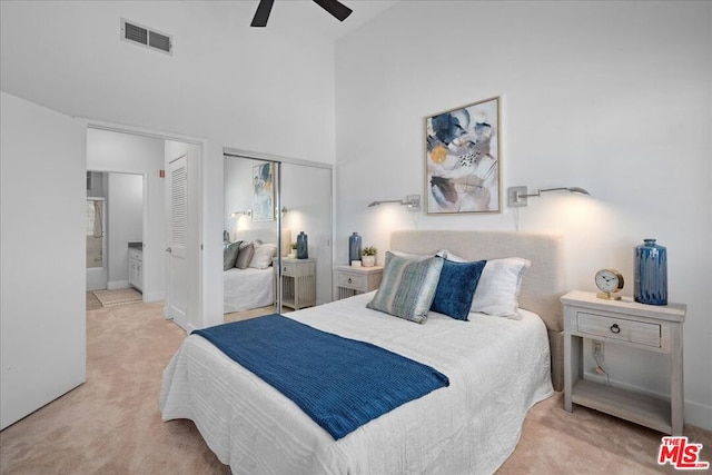 carpeted bedroom with a towering ceiling, ceiling fan, and a closet