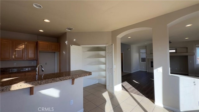 kitchen featuring light tile patterned flooring, a breakfast bar, and sink