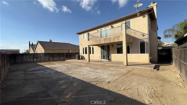 back of property featuring a balcony and a patio area