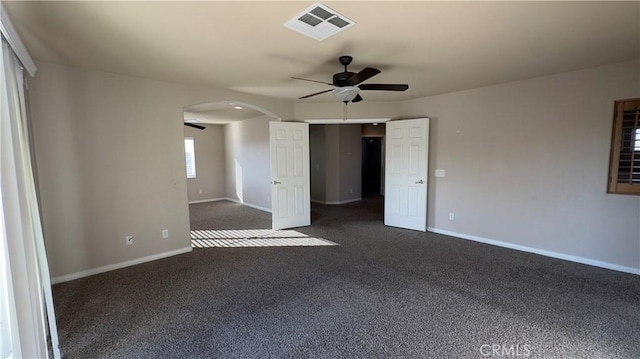 spare room featuring ceiling fan and dark colored carpet