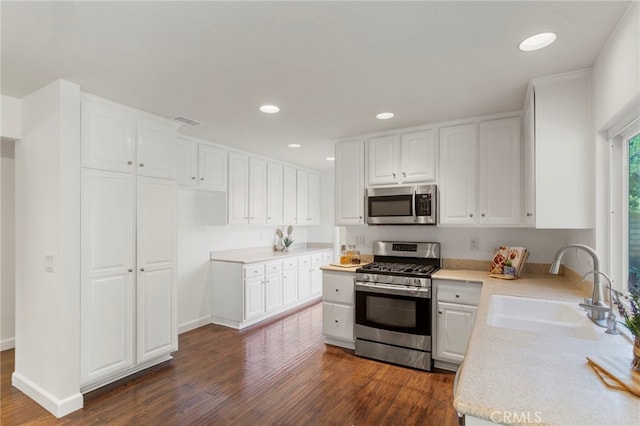 kitchen featuring stainless steel appliances, sink, white cabinets, and dark hardwood / wood-style floors