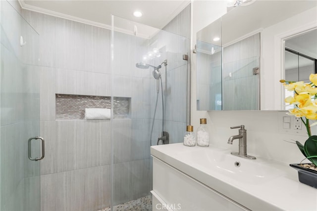 bathroom with vanity, an enclosed shower, and ornamental molding