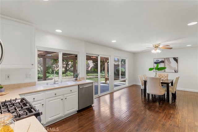 kitchen featuring sink, dishwasher, gas range oven, white cabinets, and dark hardwood / wood-style flooring