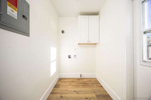 clothes washing area with cabinets, plenty of natural light, electric panel, and washer hookup