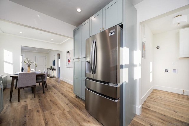 kitchen with stainless steel refrigerator with ice dispenser, ornamental molding, gray cabinetry, and light hardwood / wood-style flooring