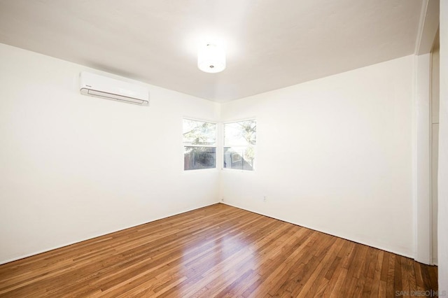 spare room with hardwood / wood-style flooring and a wall mounted AC