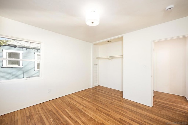 unfurnished bedroom with wood-type flooring and a closet