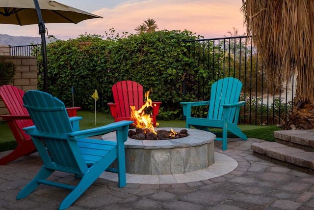 patio terrace at dusk featuring an outdoor fire pit