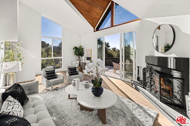 living room featuring hardwood / wood-style flooring, a wealth of natural light, wood ceiling, and high vaulted ceiling