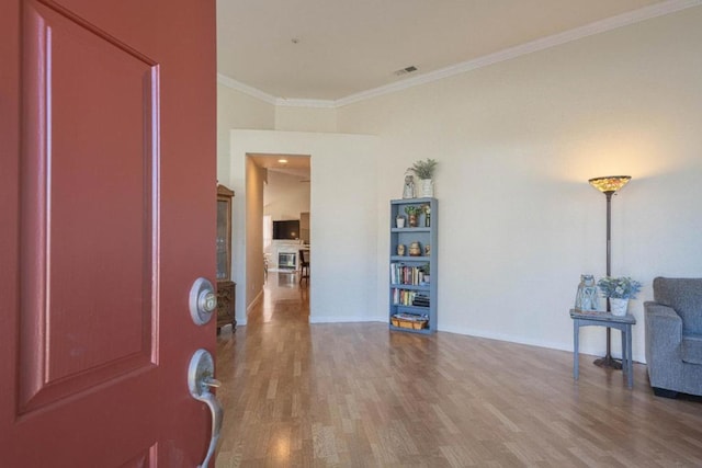 foyer with crown molding and hardwood / wood-style flooring