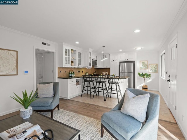 living room featuring light tile patterned floors and crown molding