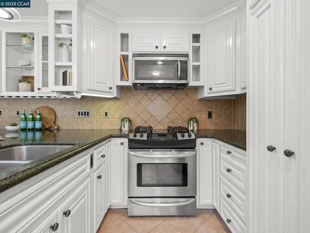 kitchen featuring white cabinetry, appliances with stainless steel finishes, backsplash, and light tile patterned floors