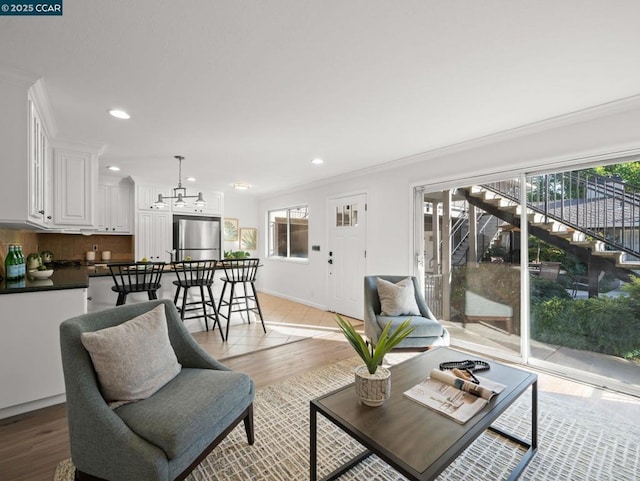 living room featuring ornamental molding and light wood-type flooring