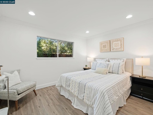 bedroom featuring ornamental molding and light wood-type flooring