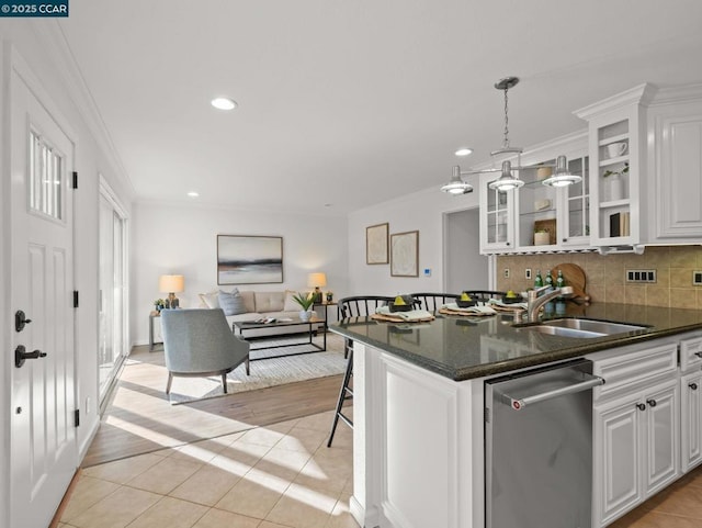 kitchen featuring pendant lighting, light tile patterned floors, sink, dishwasher, and white cabinetry