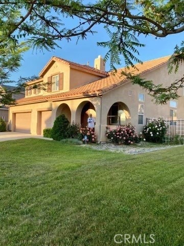 mediterranean / spanish house with a garage and a front yard