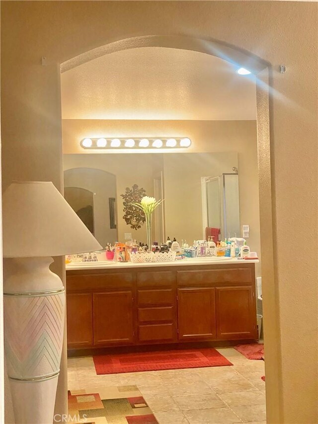 bathroom with vanity, tile patterned flooring, and a shower with door