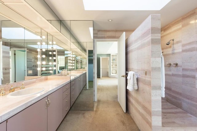 bathroom with a shower, tile walls, and vanity