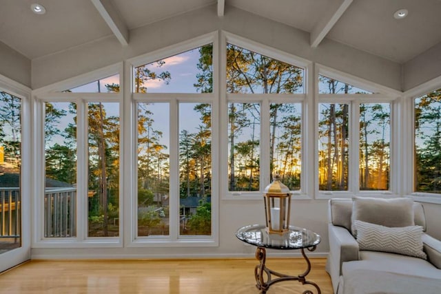 sunroom with lofted ceiling with beams and a wealth of natural light