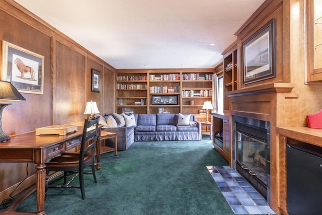 carpeted office space featuring wooden walls and built in shelves