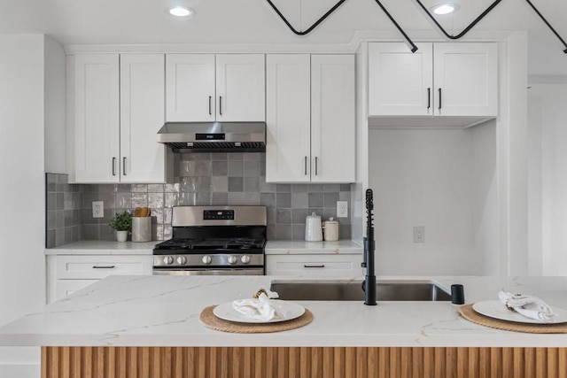 kitchen featuring sink, stainless steel range with gas cooktop, range hood, and white cabinets