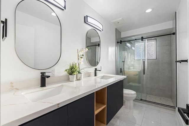 bathroom with vanity, toilet, and a shower with door