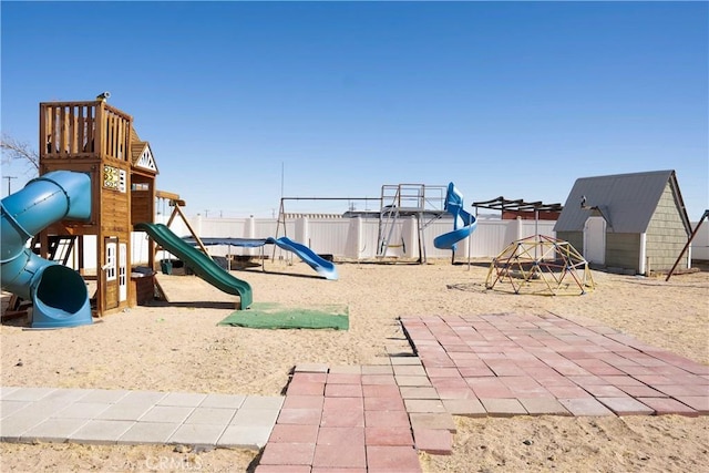 view of jungle gym with an outbuilding and fence