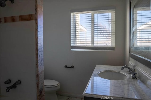 full bathroom featuring toilet, plenty of natural light, a shower, and vanity