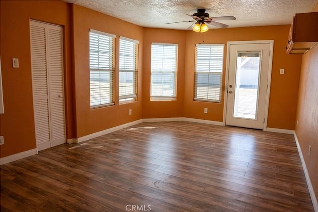 interior space with dark wood-style floors, baseboards, a ceiling fan, and a textured ceiling