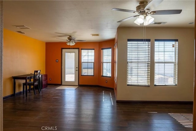 unfurnished dining area featuring wood finished floors, visible vents, and baseboards