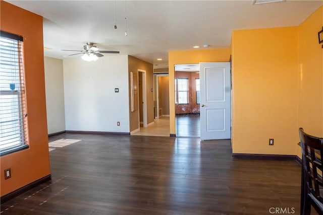 unfurnished room featuring a ceiling fan, baseboards, and wood finished floors