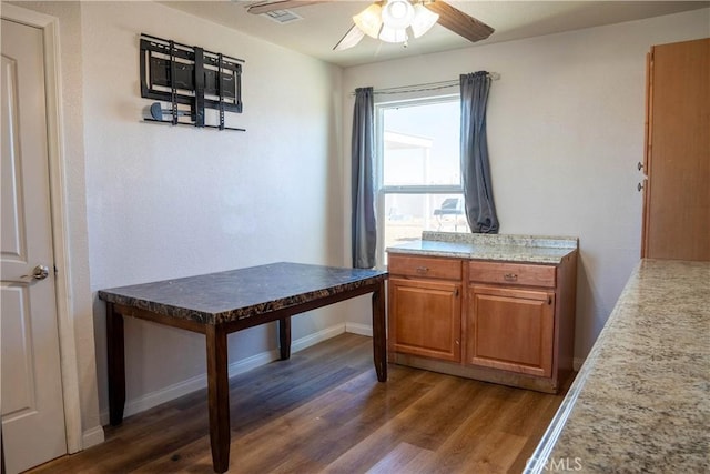 unfurnished dining area with ceiling fan, wood finished floors, visible vents, and baseboards