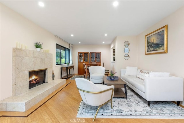 living room with a high end fireplace and wood-type flooring