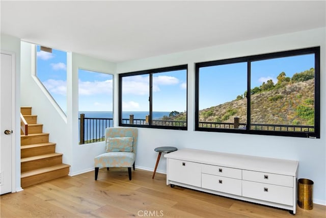 sitting room featuring a water view and light wood-type flooring