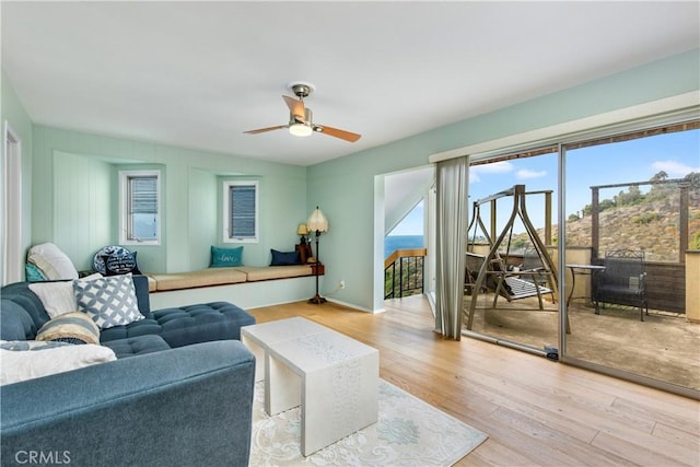 living room with ceiling fan and light hardwood / wood-style flooring