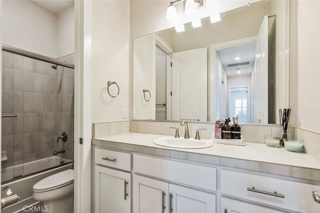 full bathroom with vanity, combined bath / shower with glass door, and toilet