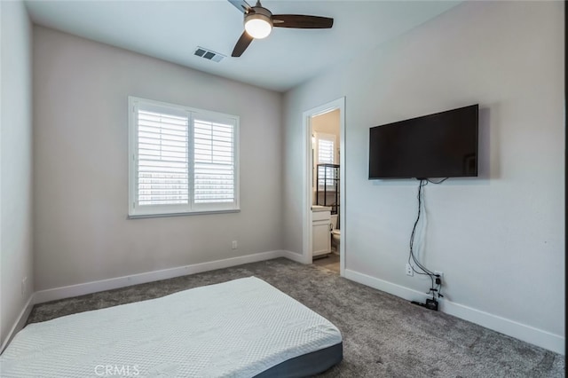 bedroom with connected bathroom, ceiling fan, and dark colored carpet