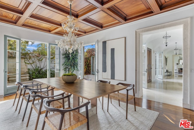 dining space featuring ornamental molding, wood-type flooring, wooden ceiling, and an inviting chandelier