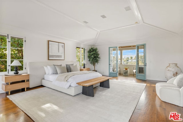 bedroom with wood-type flooring, lofted ceiling, and access to outside