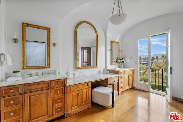 bathroom with lofted ceiling, vanity, and hardwood / wood-style floors