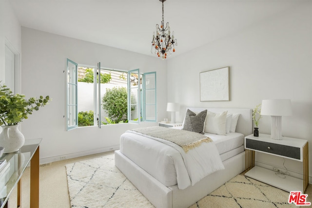 bedroom featuring light carpet and a notable chandelier