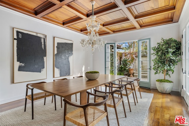 dining area featuring crown molding, wooden ceiling, a chandelier, and light hardwood / wood-style flooring