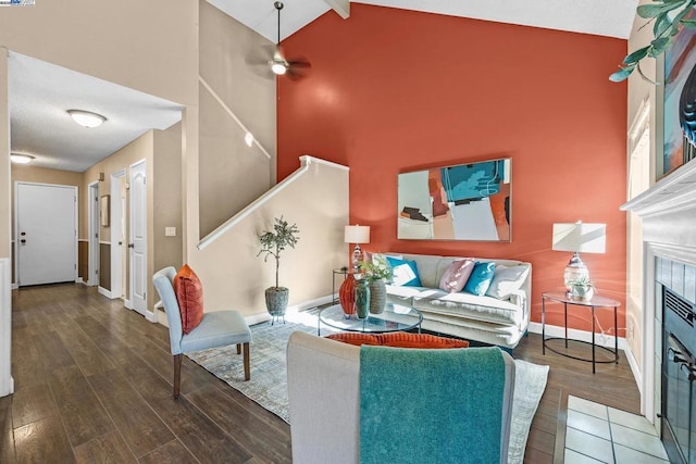 living room featuring beamed ceiling, ceiling fan, dark wood-type flooring, and high vaulted ceiling