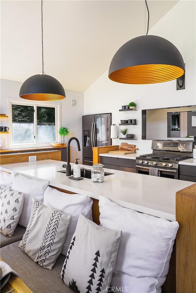 kitchen with vaulted ceiling, appliances with stainless steel finishes, sink, and hanging light fixtures