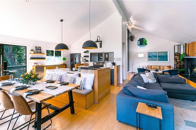 living room with sink, light hardwood / wood-style flooring, and high vaulted ceiling