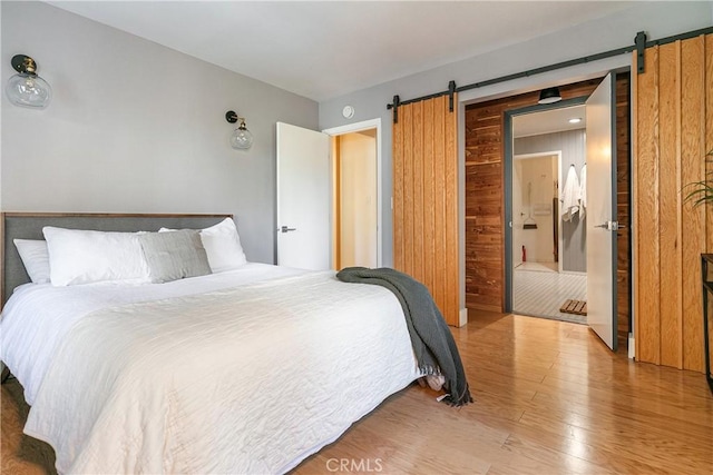 bedroom with hardwood / wood-style flooring and a barn door