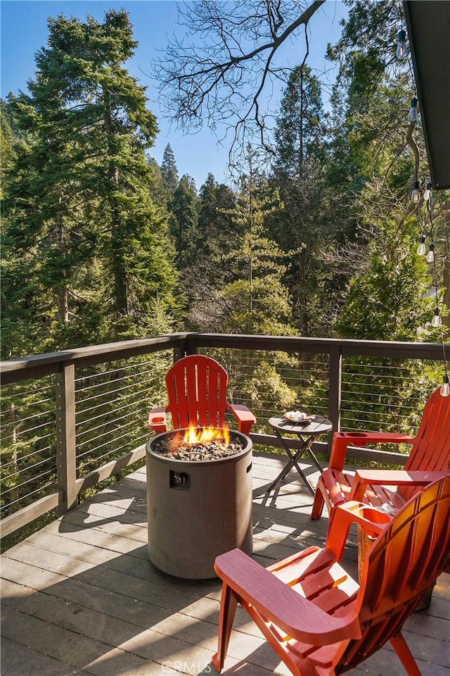 wooden balcony with a wooden deck and an outdoor fire pit