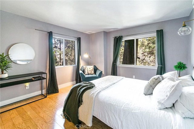 bedroom with hardwood / wood-style flooring and multiple windows