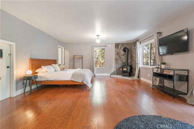 bedroom with hardwood / wood-style flooring and a wood stove