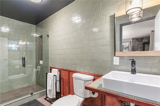 bathroom with tile walls, sink, toilet, and walk in shower